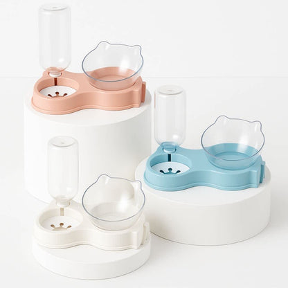 Comederos automáticos dobles en colores rosa, azul y blanco sobre pedestales blancos minimalistas