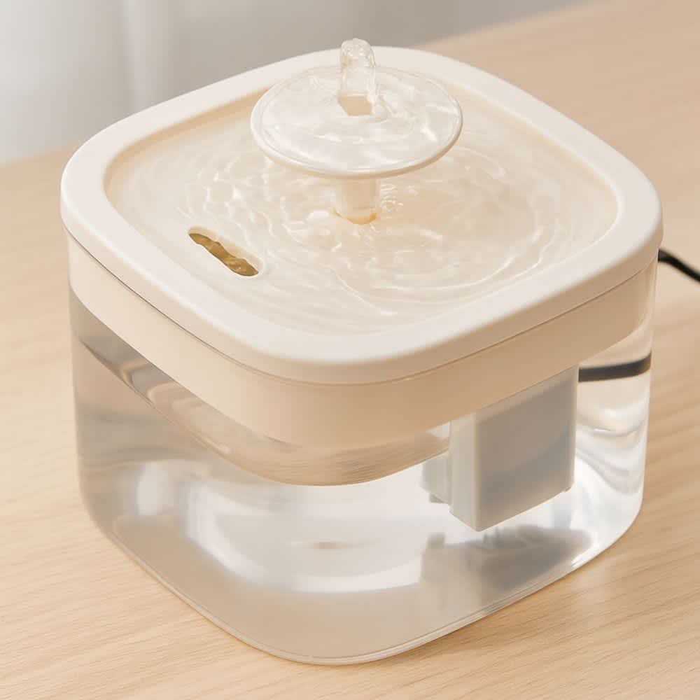 Detalle de tapa superior beige mostrando flujo de agua constante en fuente para gatos