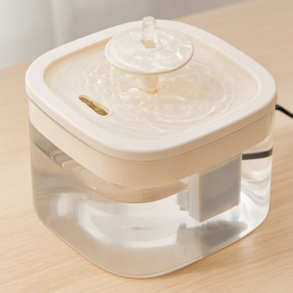 Detalle de tapa superior beige mostrando flujo de agua constante en fuente para gatos
