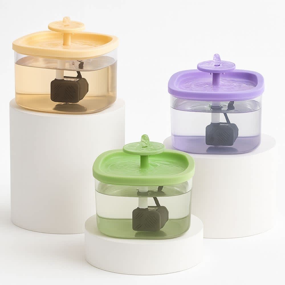 Fuentes de agua silenciosas para gatos en colores beige, verde y morado sobre pedestales blancos minimalistas